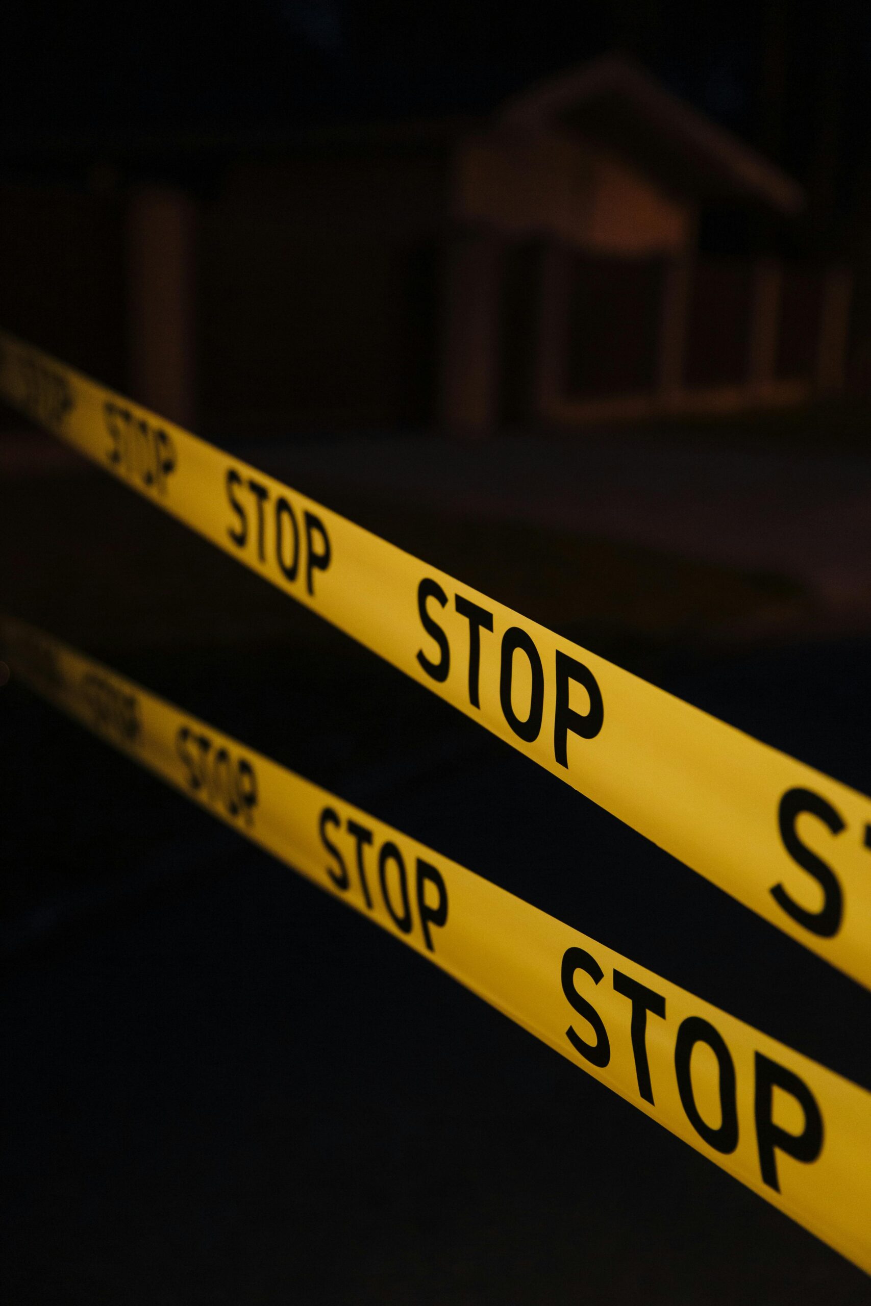 Yellow stop tape in a night crime scene setup, creating a tense atmosphere.