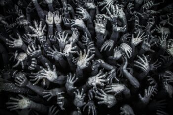 A haunting display of numerous grey hands reaching upward at Wat Rong Khun, Thailand.