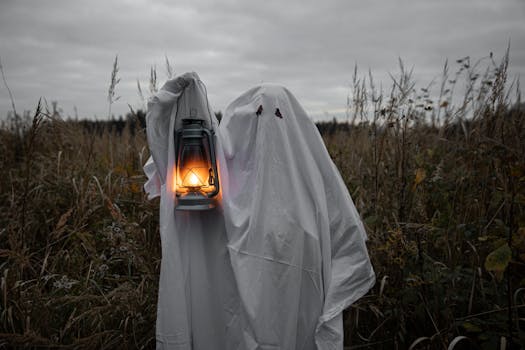 A ghostly figure holds a lantern in a dark, spooky field, embodying Halloween spirit.